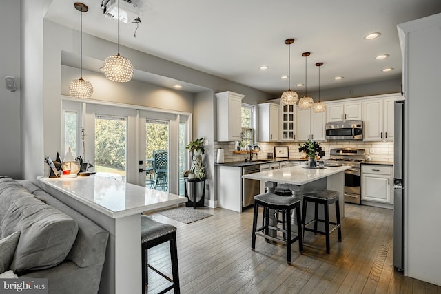 kitchen featuring a sink, stainless steel appliances, a kitchen bar, and dark wood finished floors