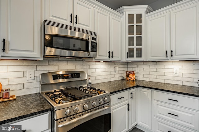 kitchen featuring backsplash, stainless steel appliances, glass insert cabinets, and white cabinetry