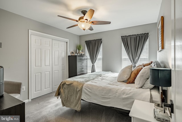 carpeted bedroom featuring a closet, baseboards, and a ceiling fan