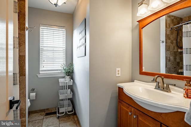 full bath with toilet, a tile shower, tile patterned flooring, baseboards, and vanity