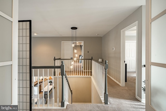 stairway featuring baseboards and carpet flooring