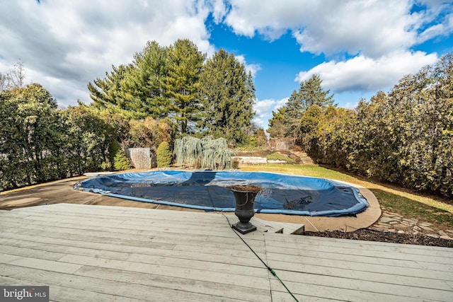 view of swimming pool featuring a covered pool and a deck