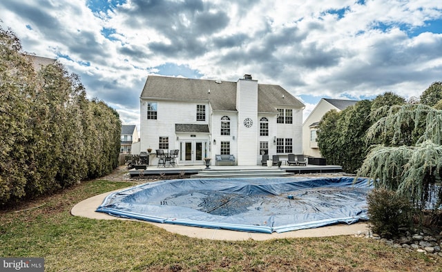 view of swimming pool featuring french doors and a deck