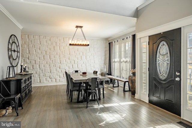 dining room with visible vents, baseboards, a chandelier, ornamental molding, and hardwood / wood-style flooring