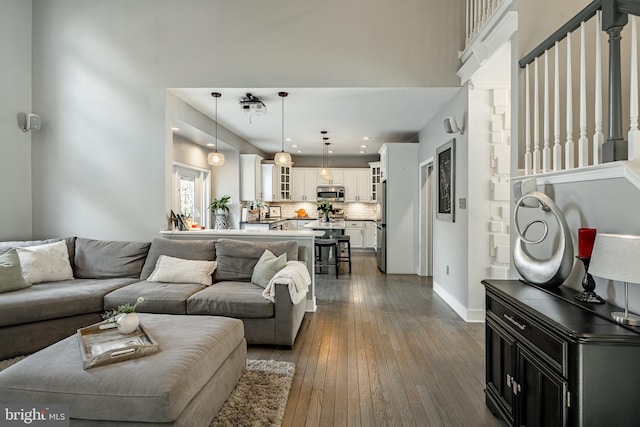 living area featuring baseboards and dark wood-style floors