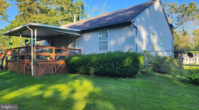 view of side of home featuring a yard, fence, and a wooden deck