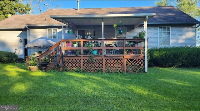 rear view of house featuring a lawn and a wooden deck