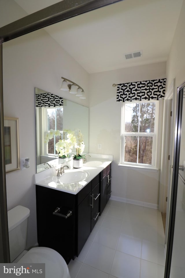 bathroom with double vanity, toilet, visible vents, and a sink