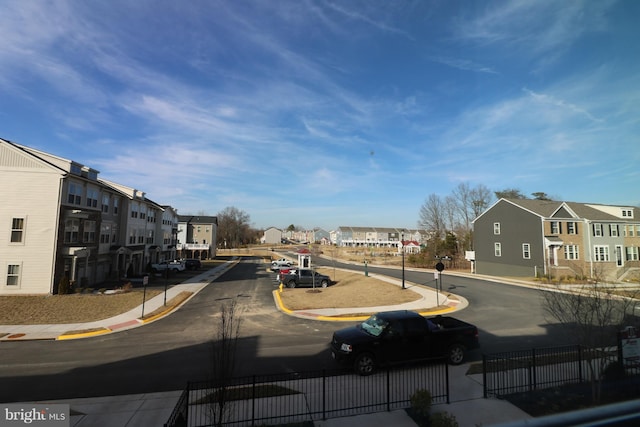 view of road featuring sidewalks, a residential view, curbs, and traffic signs