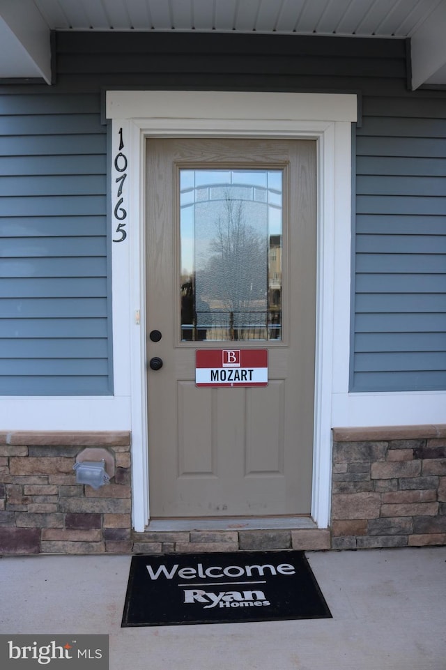 view of exterior entry featuring stone siding