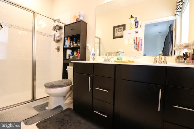 bathroom featuring a shower stall, toilet, double vanity, and a sink