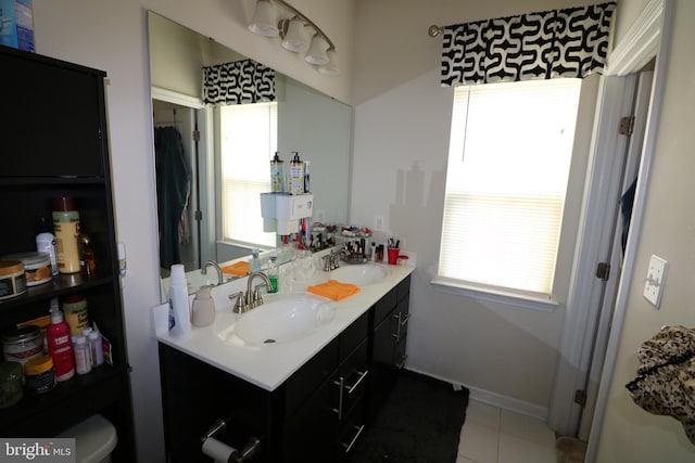 bathroom featuring a sink, toilet, double vanity, and tile patterned floors