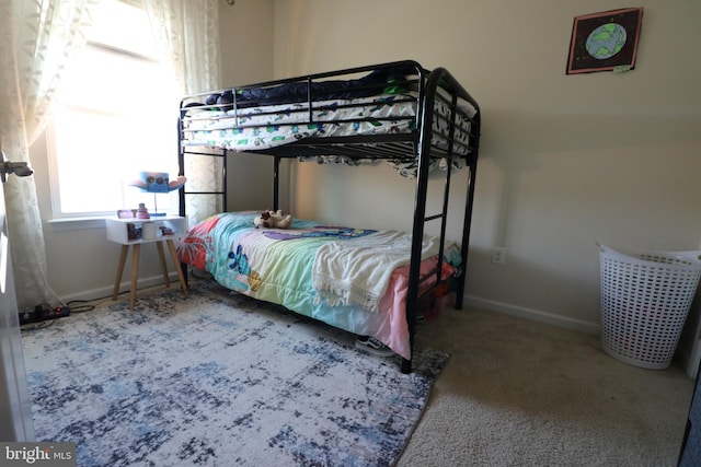 bedroom featuring baseboards and carpet