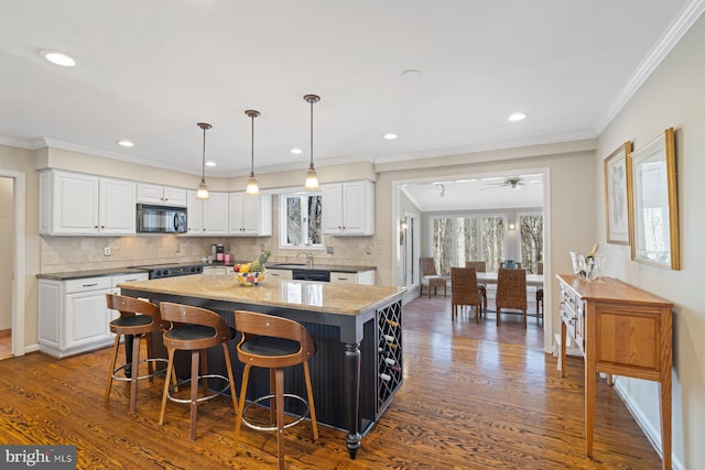 kitchen featuring black appliances, dark wood-style floors, white cabinets, and a center island