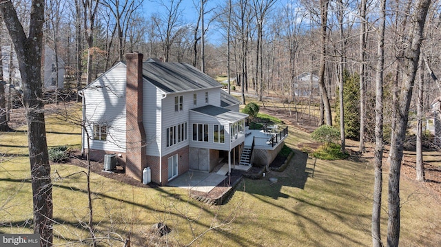 exterior space featuring a yard, cooling unit, stairway, a wooden deck, and a chimney