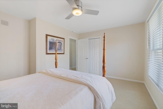 bedroom with visible vents, baseboards, light carpet, a closet, and a ceiling fan