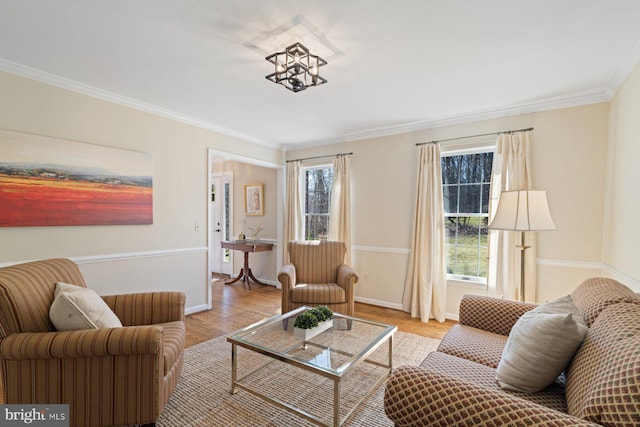 living area featuring crown molding, baseboards, and wood finished floors