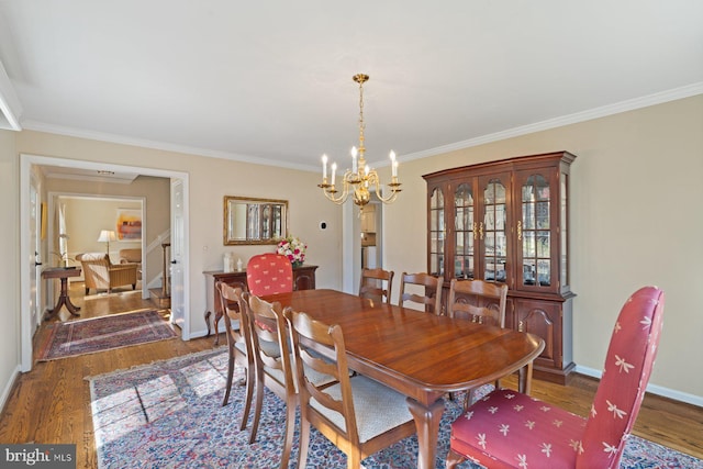 dining room featuring baseboards, a notable chandelier, wood finished floors, and ornamental molding