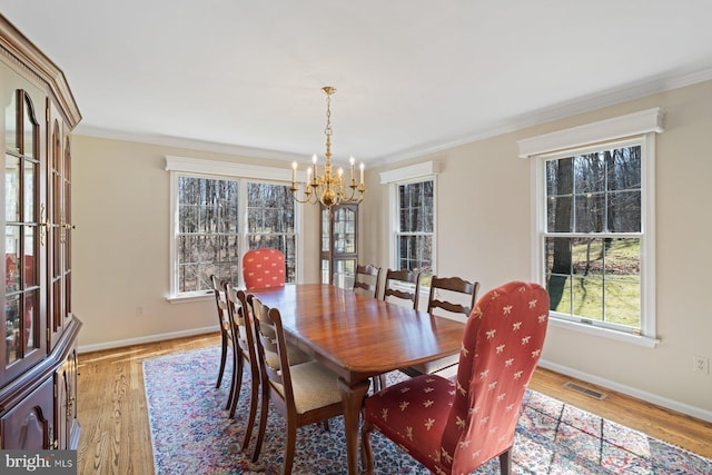 dining room with crown molding and light wood finished floors