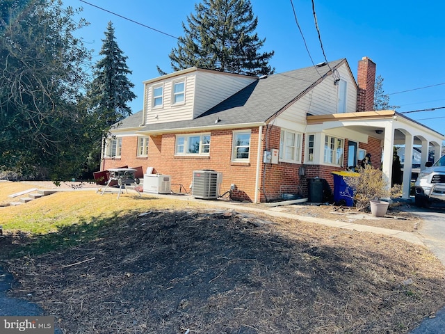 exterior space featuring brick siding and cooling unit