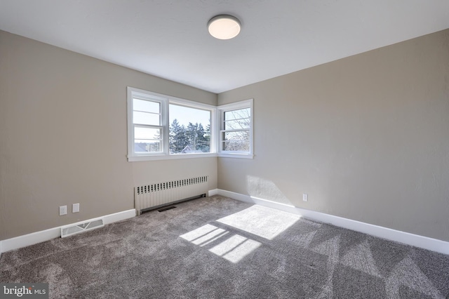 unfurnished room featuring visible vents, radiator, baseboards, and carpet