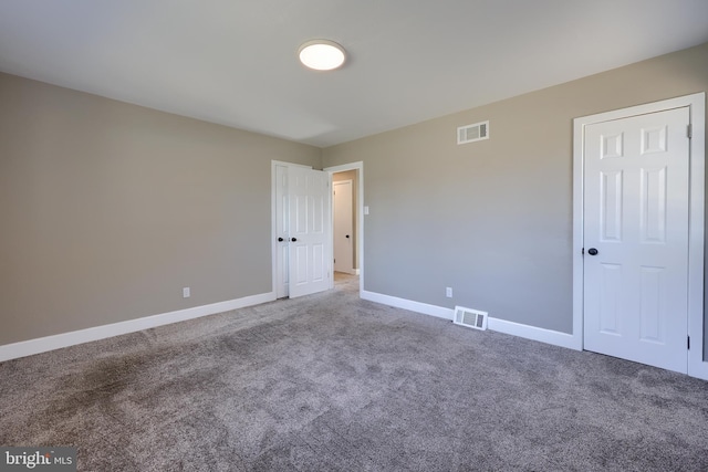 unfurnished bedroom featuring carpet flooring, baseboards, and visible vents