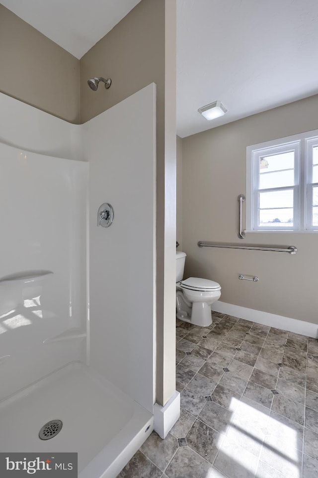 full bath with a shower stall, toilet, and baseboards