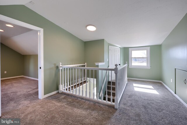 additional living space featuring vaulted ceiling, carpet, and baseboards