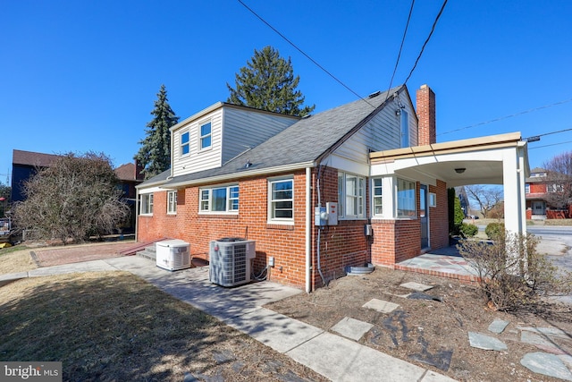 exterior space featuring central air condition unit and brick siding