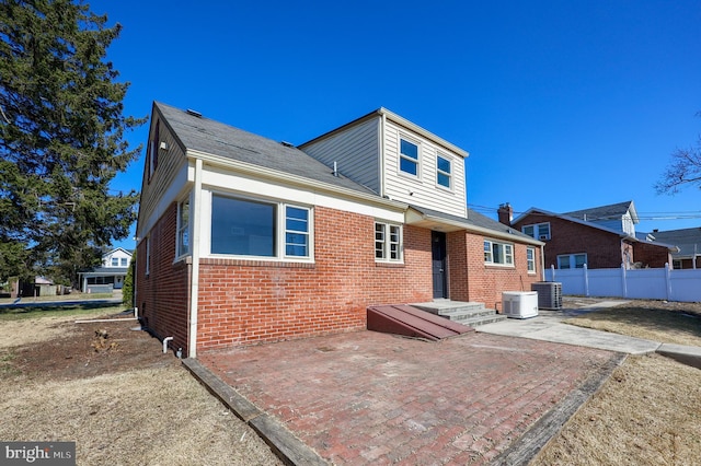 back of property featuring a patio area, central AC, brick siding, and fence