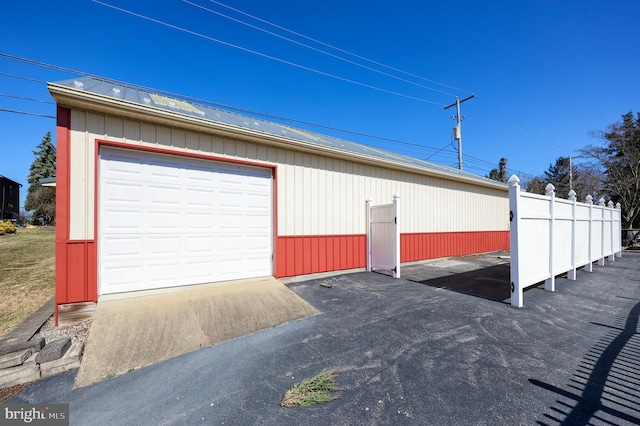 detached garage featuring fence