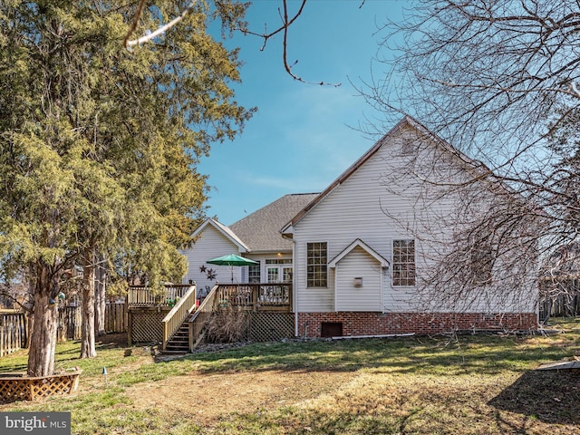 rear view of house with stairway, a lawn, and a deck