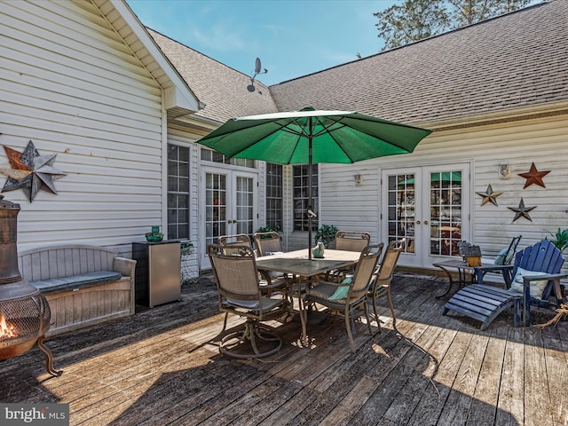 wooden terrace with outdoor dining area and french doors