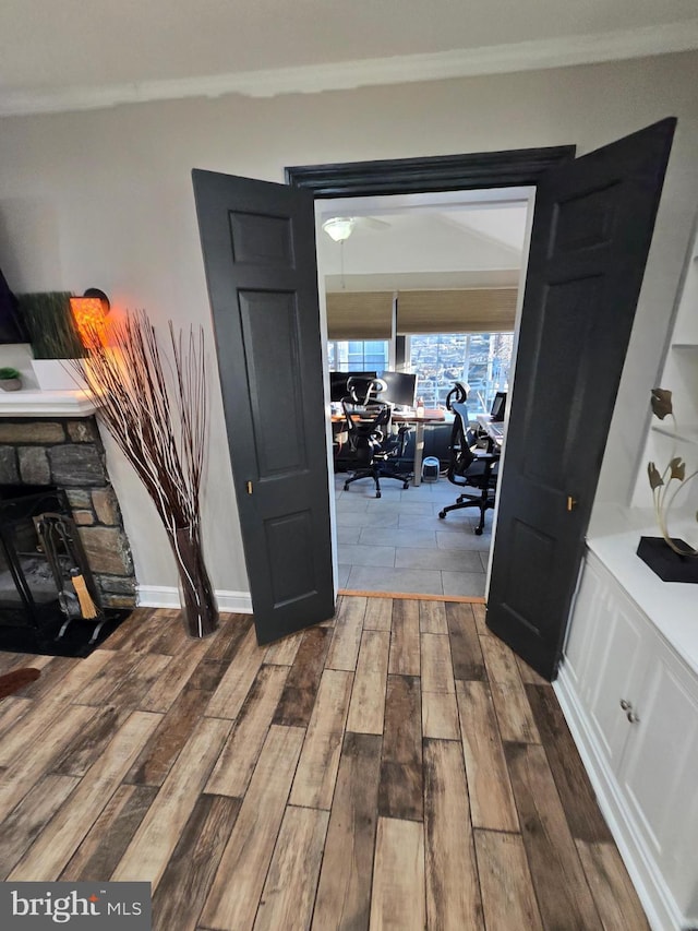 interior space with ornamental molding, baseboards, and wood finished floors