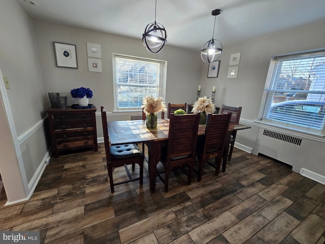 dining area with radiator heating unit, baseboards, and dark wood finished floors