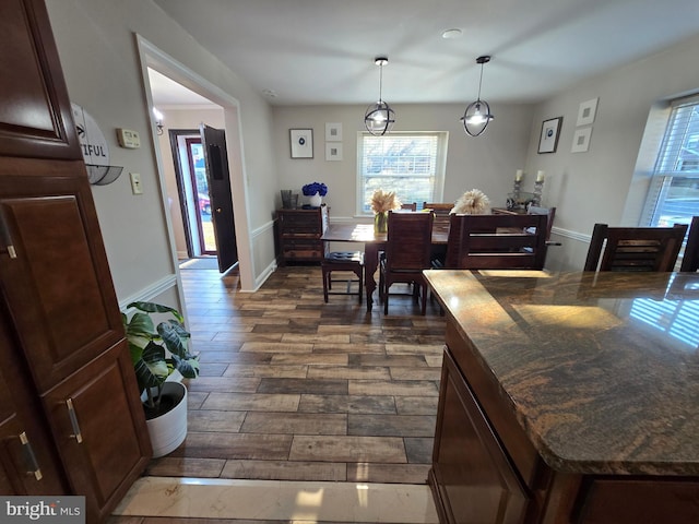 dining space with dark wood-style floors and baseboards