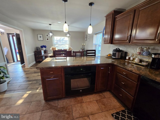 kitchen featuring plenty of natural light, black appliances, a peninsula, and backsplash