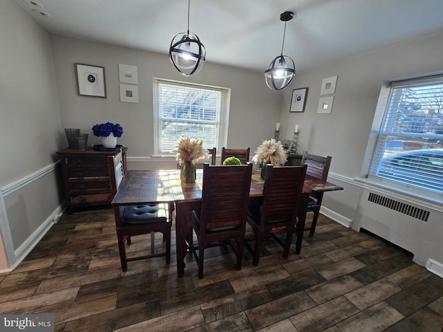 dining room with radiator heating unit, dark wood finished floors, a wealth of natural light, and baseboards