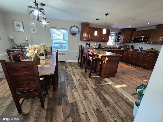 kitchen featuring stainless steel appliances, backsplash, dark wood finished floors, and radiator