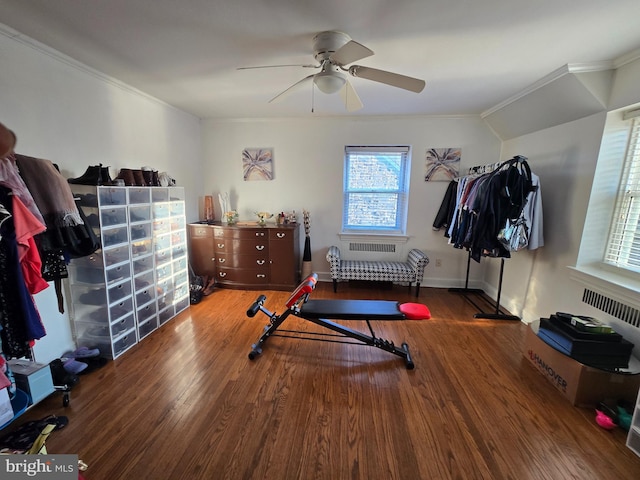 workout area with a ceiling fan, crown molding, baseboards, and wood finished floors