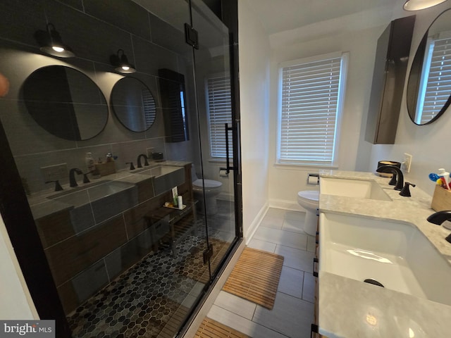 bathroom with a stall shower, a sink, and toilet