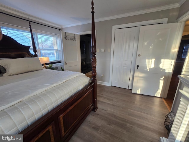 bedroom featuring a closet, baseboards, crown molding, and wood finished floors