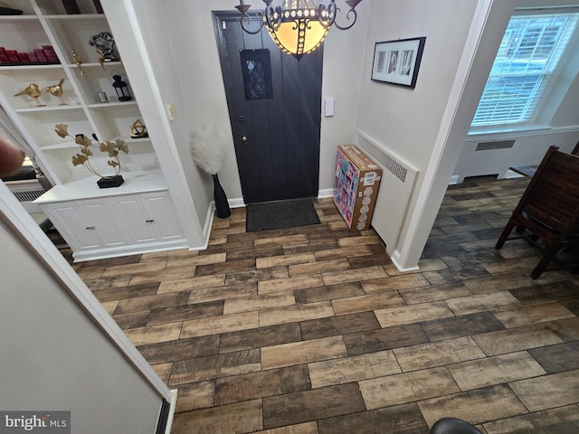 entrance foyer with baseboards, dark wood-style flooring, and a notable chandelier