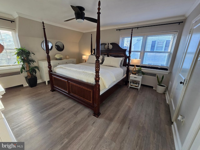 bedroom with vaulted ceiling, radiator heating unit, wood finished floors, and crown molding