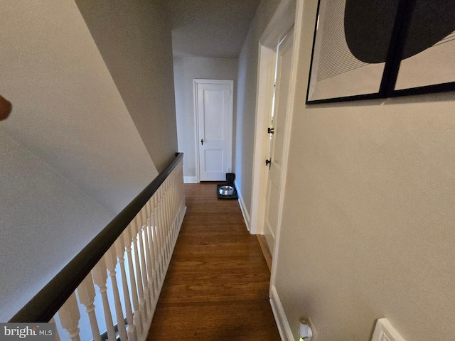 corridor with baseboards and wood finished floors