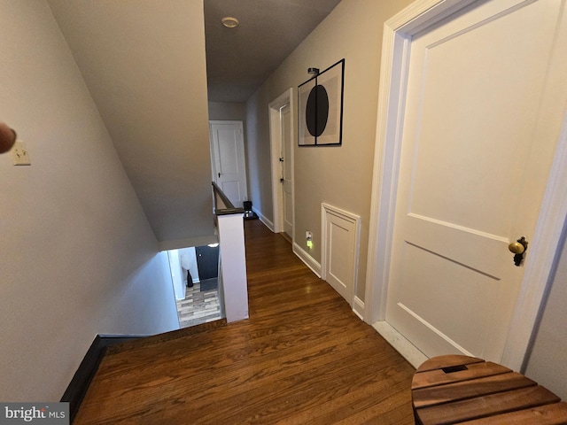 hallway with dark wood finished floors and baseboards