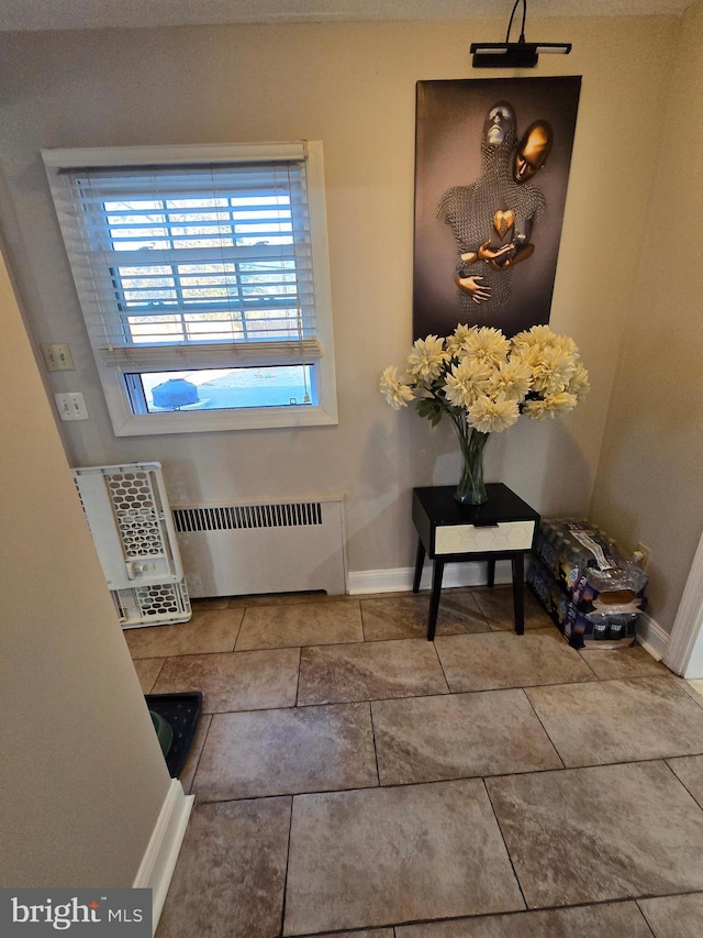 interior details with radiator heating unit and baseboards