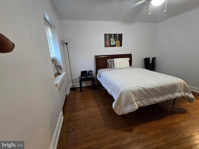 bedroom with a ceiling fan, crown molding, baseboards, and wood finished floors