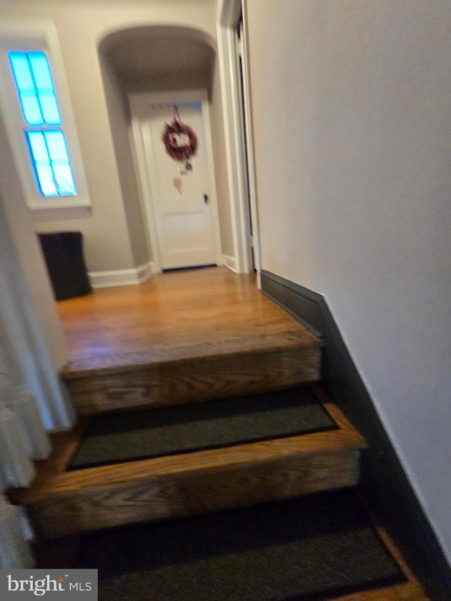 stairs featuring wood finished floors and baseboards