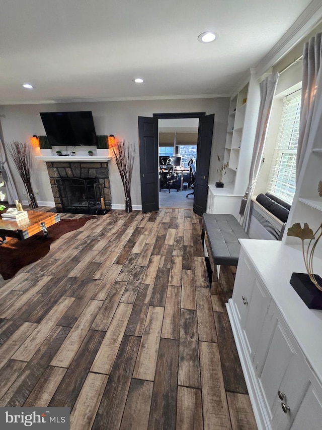 interior space with ornamental molding, dark wood-style flooring, a fireplace, and recessed lighting